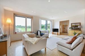 a living room with two couches and a television at Brook Lodge Farm in Isfield