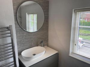 a bathroom with a white sink and a mirror at Cottage by the Castle grade II in Kenilworth +39 photos