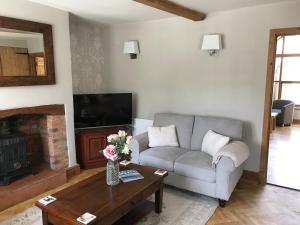 a living room with a couch and a fireplace at Cottage by the Castle grade II in Kenilworth