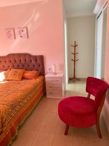 a bedroom with a red bed and a red chair at Ótimo AP 2 Dorm com suíte prox ao Consulado Americano in Porto Alegre