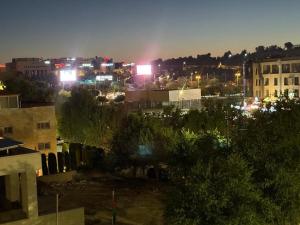 Una vista de una ciudad de noche con luces. en Furnished luxuries Apartment with a Stunning View, en Amán