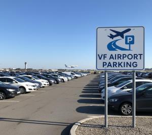 a parking lot with a parking sign in front of cars at VF Park -Reptéri Parkoló Vecsés Ingyenes Transzfer in Vecsés