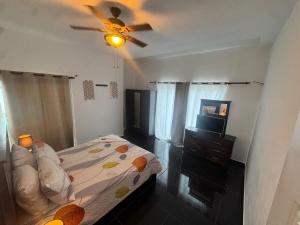 een slaapkamer met een bed en een plafondventilator bij Modern 3-Bedroom Apartment with Pool in Boca Chica +18 foto's