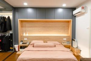 a bedroom with a large bed with a wooden headboard at Genesis Unique Comfy Loft - Spacious 5BR in Kota Kinabalu
