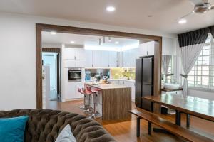a kitchen and living room with a couch and a table at Genesis Unique Comfy Loft - Spacious 5BR in Kota Kinabalu