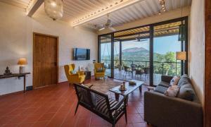 uma sala de estar com um sofá e uma mesa em SaffronStays Satori Perch Regal - 4BR Tuscan-style villa with pool, farm meals & 270 Degree Mulshi Lake views near Pune em Mulshi