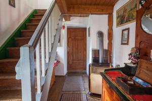 a hallway with a staircase and a wooden door at Mountain-view Cottage Sleeps 15 -Balcony -Pets Ok in Bicheln