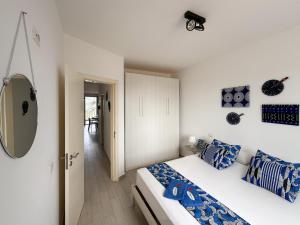 a bedroom with a bed with blue pillows and a mirror at I LOVE BOA VISTA - Seafront Apartments in Sal Rei