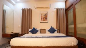 Un dormitorio con una cama grande con almohadas azules. en Arrow Service Appartment, en Gachibowli
