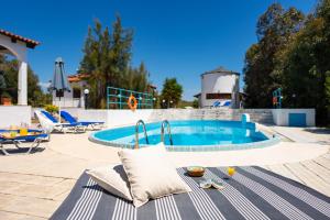 een zwembad met een tafel en stoelen ernaast bij Villas Mina and Studios in Gennadi +30 foto's