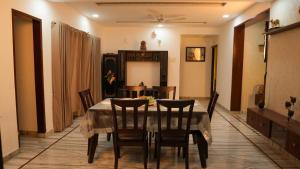 Un comedor con mesa y sillas en Arrow Service Appartment, en Gachibowli