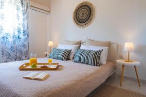 een bed met een dienblad met eten en drinken erop bij Villas Mina and Studios in Gennadi