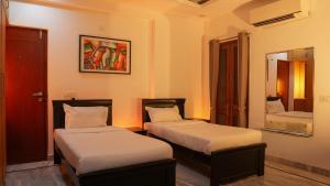 Un dormitorio con dos camas y un espejo. en Arrow Service Appartment, en Gachibowli 11 fotos más