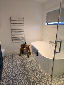 a bathroom with a tub and a sink and a toilet at CERULEAN HOUSE - Iconic Renovated Period Home - Close to Everything in Bendigo +7 photos