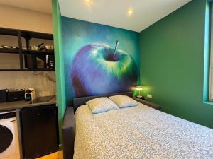ヴェニシューにあるApple suite - studio Lyonのリンゴの絵が飾られたベッドのある寝室