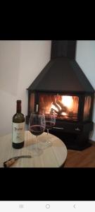 two glasses of wine sitting on a table with a fireplace at Alojamiento rural El Yate in Montefrío