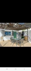 a patio with a table and chairs and a stove at Alojamiento rural El Yate in Montefrío
