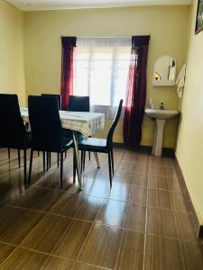 uma sala de jantar com uma mesa e cadeiras e um lavatório em 3 Bedroom Own Compound em Melinde