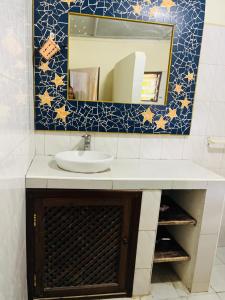 um banheiro com uma pia e um espelho em 3 Bedroom Own Compound em Melinde