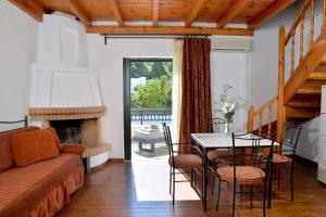 a living room with a couch and a table with chairs at Vasilaras Hotel in Skala