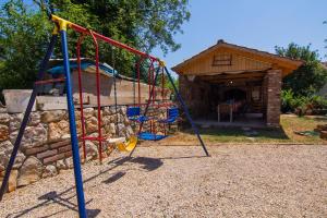 a playground with a slide in front of a house at Villa Novkovic in Žgaljić