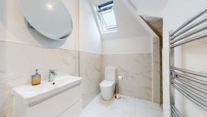 a white bathroom with a sink and a toilet at Luxury Penthouse Duplex in Newport +28 photos