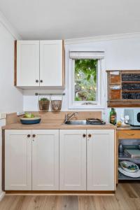 a kitchen with white cabinets and a sink at Studio Spring Hill Holiday Units Pet friendly in Point Lonsdale