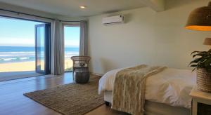 a bedroom with a bed and a view of the ocean at Secret Sunrise in Jeffreys Bay