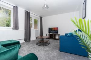 a living room with couches and a table and a tv at Maple - Telford House - With Parking in Telford