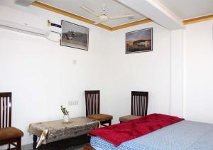 a bedroom with a bed and a table and chairs at Pink City Heritage Homestay in Jaipur