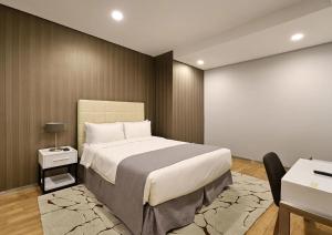 a bedroom with a large bed and a desk at UH FLAT Hotels & Resorts in Iskandar Puteri