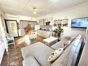 a living room with a couch and a kitchen at Leopard Corner Lodge in St Lucia