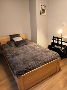- un grand lit dans une chambre avec un bureau dans l'établissement Apartament dwupoziomowy Dom na patio Kościuszki self-check-in, à Katowice