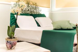 a room with a bed and a vase with flowers on a table at Relais Pian delle Starze in Marina di Camerota