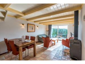 a living room with a wooden table and chairs at Lovely Holiday Home in Texel near Sea in Oost +16 photos