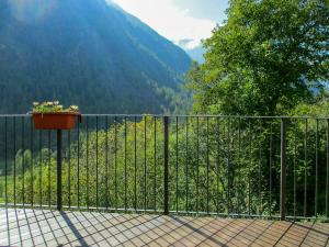 a balcony with a fence and a pot of flowers at Stone Cabin With Views Over Balme Valley in Ala di Stura +12 photos