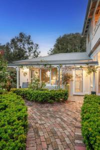 a white house with a brick patio at Unit 2 Spring Hill Holiday Units - Pet friendly in Point Lonsdale