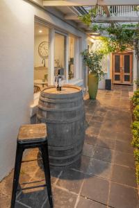 a barrel sink in the middle of a patio with a stool at Unit 2 Spring Hill Holiday Units - Pet friendly in Point Lonsdale +12 photos