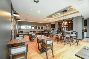 a dining room with tables and chairs in a restaurant at Premier Inn Karlsruhe City Am Wasserturm in Karlsruhe