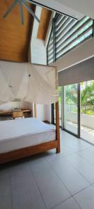 a bedroom with a bed with a large window at Villa golf de Montchoisy in Mont Choisy