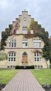 a large brick building with ivy growing on it at Prize by Radisson, Osnabruck in Osnabrück