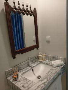 a bathroom with a sink and a mirror at Oak Tree House- Ponta do Pargo in Lombada Velha