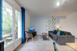 Una sala de estar con un sofá y una ventana. en Appartement hyper centre - Parking - 2v, en Tours