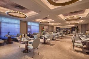 a restaurant with tables and chairs and chandeliers at Mercure Xi'an History Museum in Xi'an