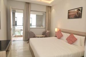 a bedroom with a large white bed and a window at Poonam Aayati in Varanasi