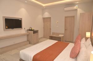 a hotel room with a bed and a television at Poonam Aayati in Varanasi