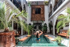 a woman standing in the middle of a pool in a building at Riad NL&S Collection in Marrakech