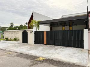 a house with a black gate and a driveway at Taiping Corner Homestay in Taiping