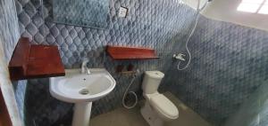 a small bathroom with a sink and a toilet at Nionje Garden Villa in Jambiani