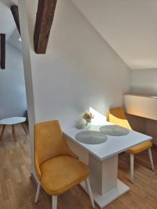 a dining room with a white table and chairs at City Nest Apartments NS in Novi Sad